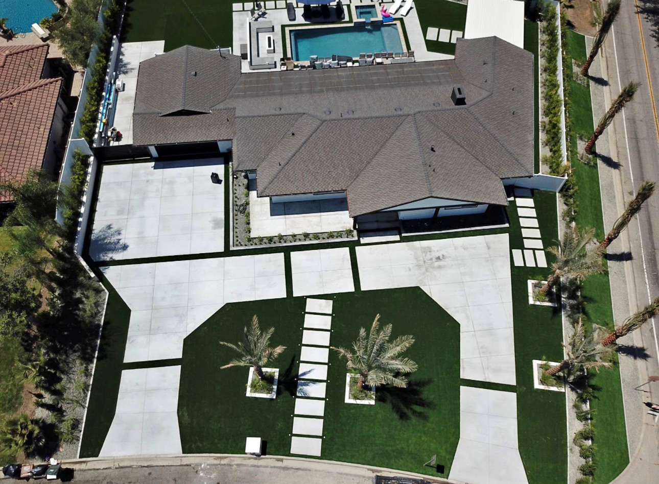 Top-down view of the finished front yard with turf panels, palms and stepping stones