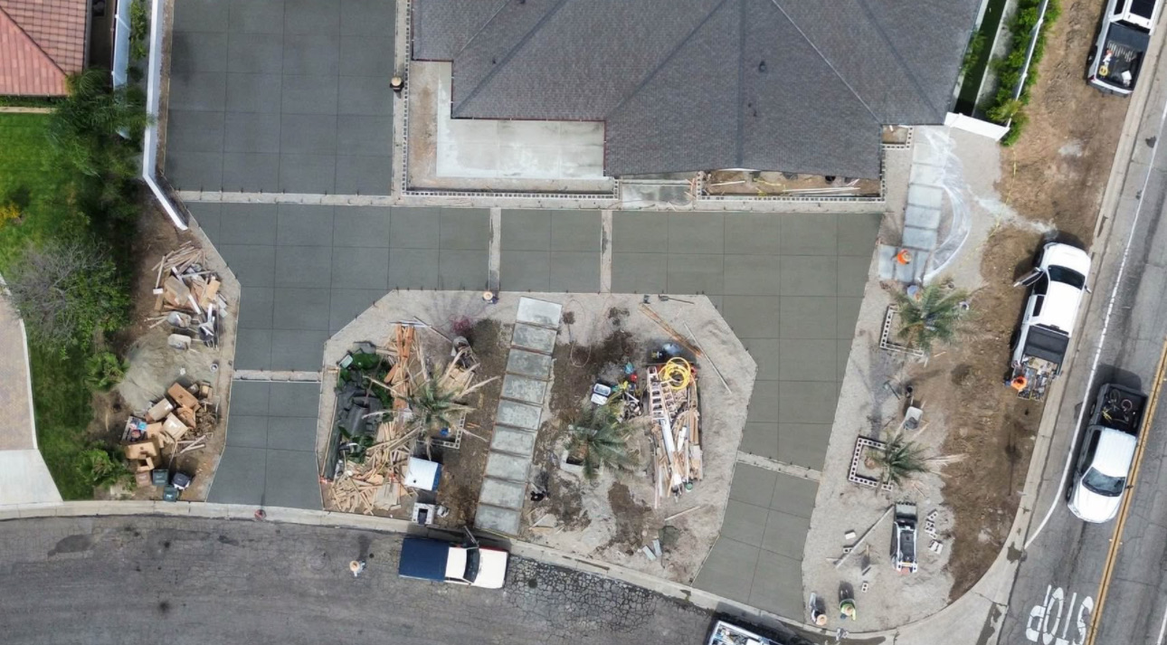 Aerial view of the estate mid-build with fresh concrete flatwork and planter cutouts