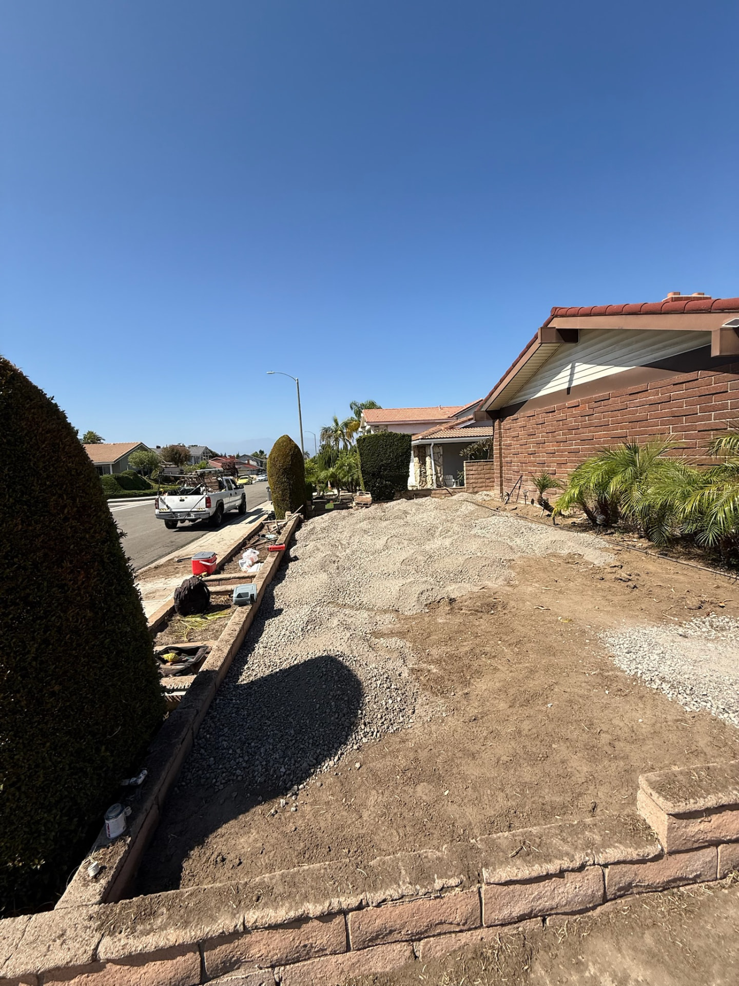Sloped front yard graded to dirt and gravel before install
