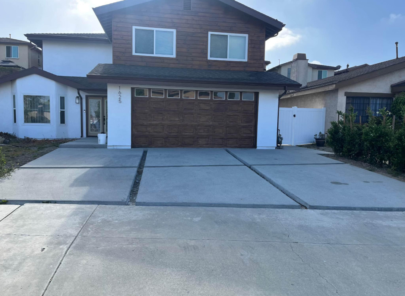 Plain concrete driveway with bare dirt front yard before install