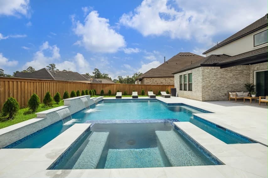 Geometric pool with sheer descent water wall and sunken spa in a Houston backyard