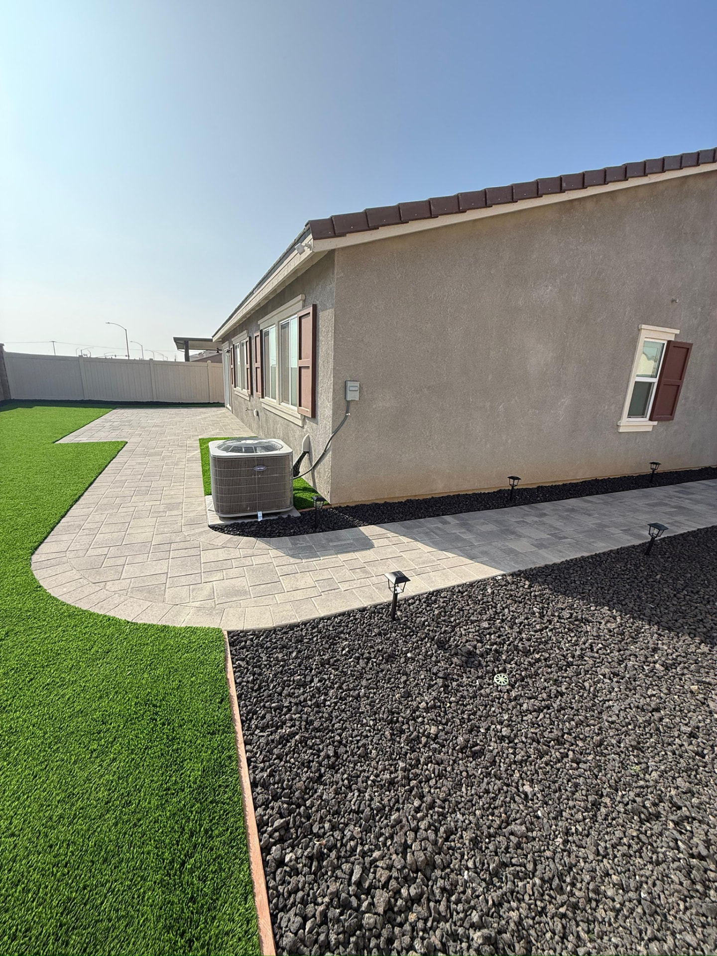 Paver walkway, turf and lava rock beds with path lighting