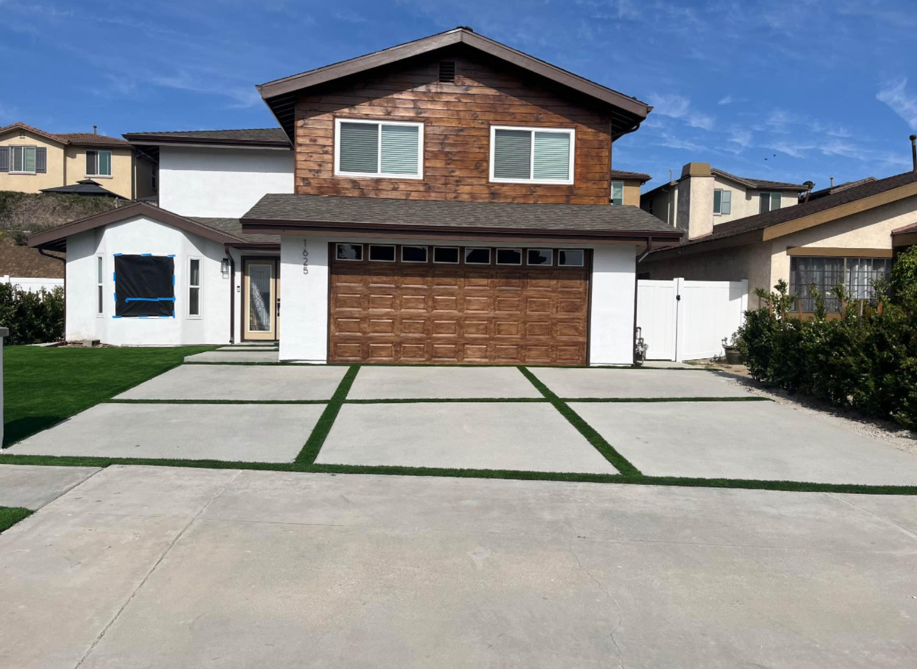 Finished driveway with turf ribbon strips between concrete panels and new front lawn