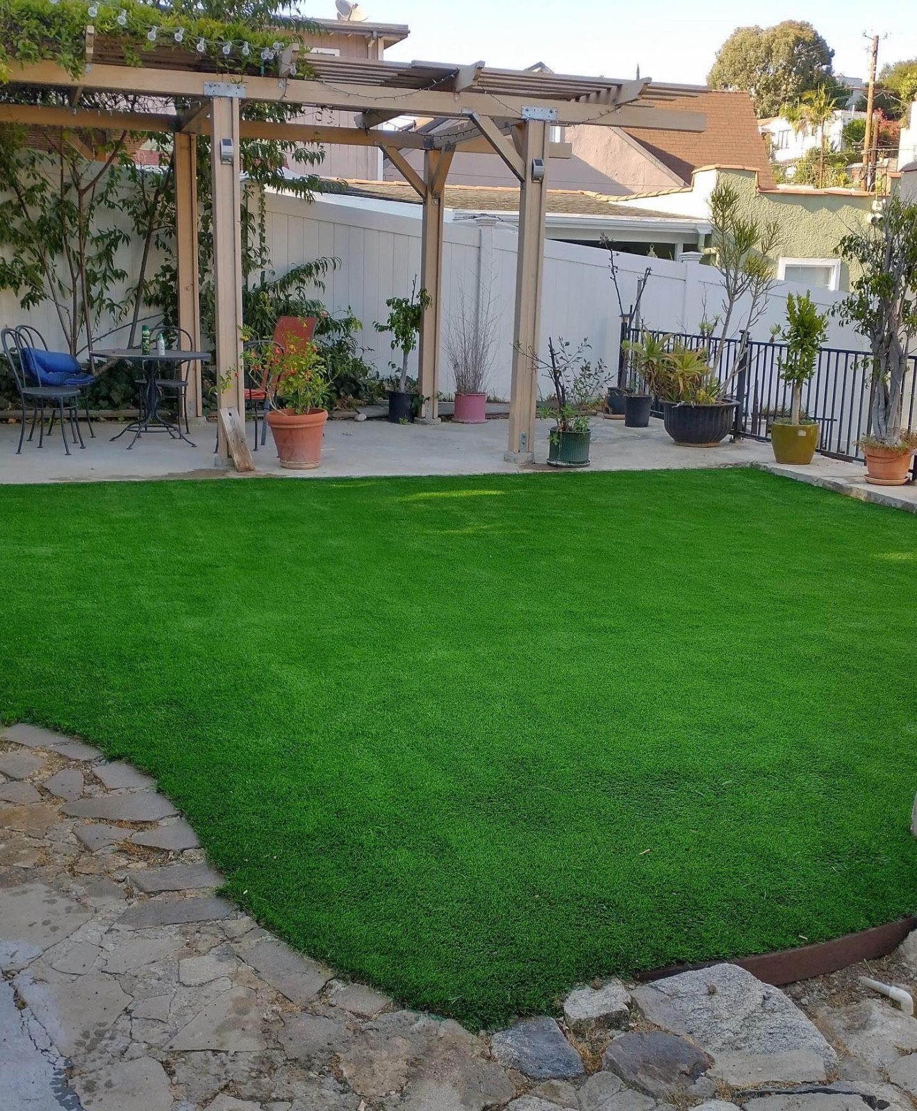 Finished backyard turf lawn under the pergola with patio seating