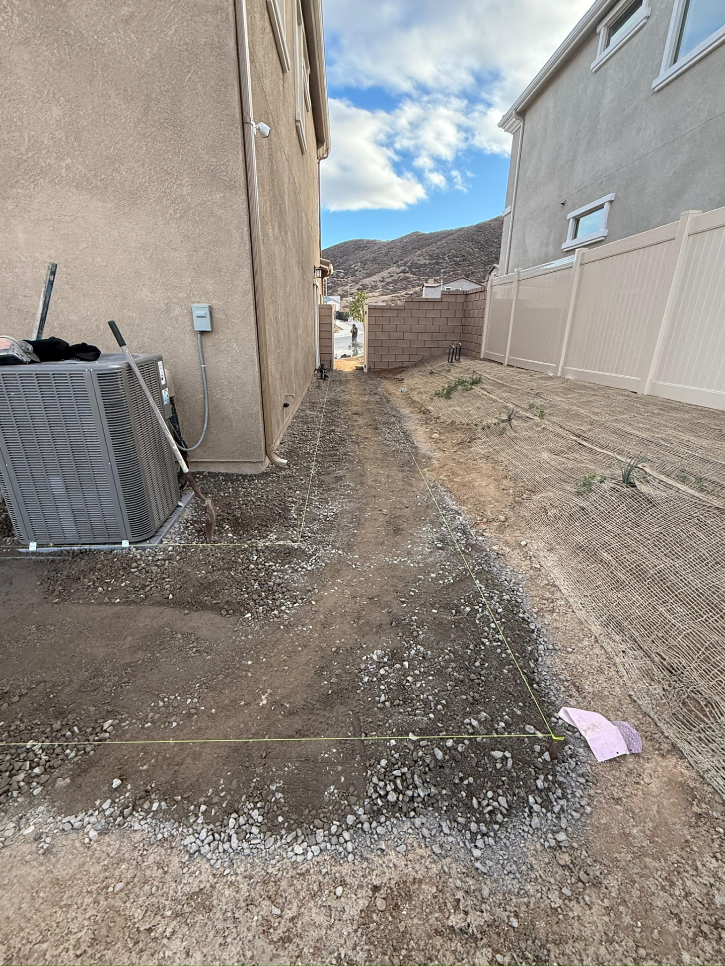 Bare dirt and gravel side yard before work