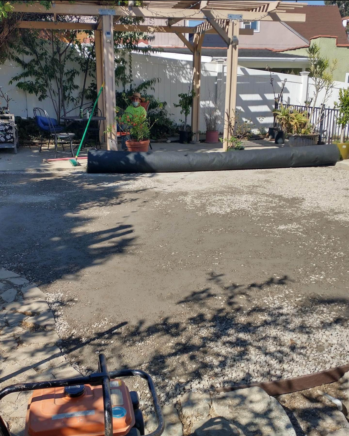 Backyard stripped to compacted base with turf roll ready to lay