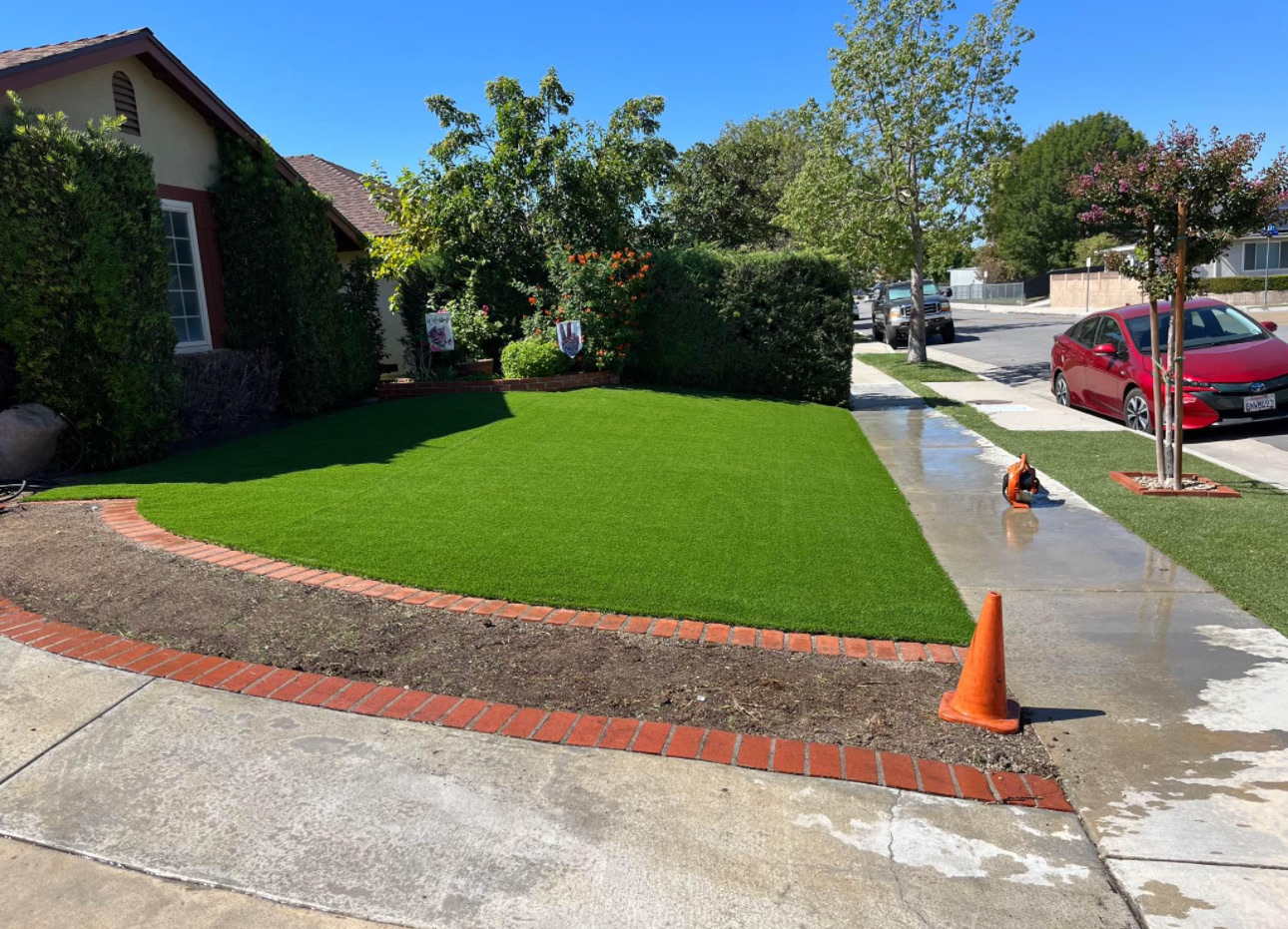 Finished curved turf lawn inside restored brick border