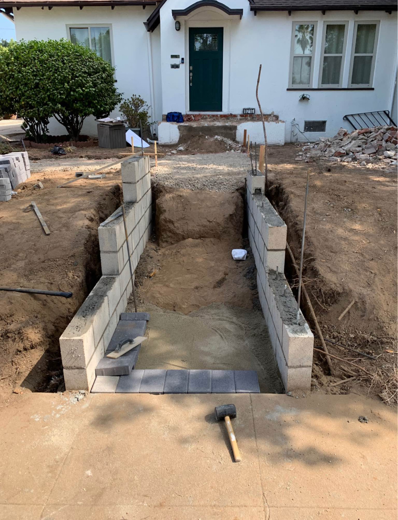Entry stairway excavated with block retaining walls under construction