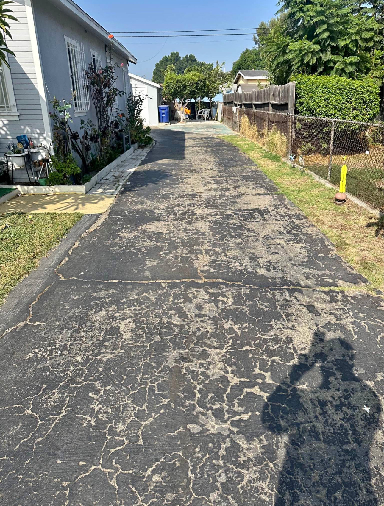Crumbling asphalt driveway before removal